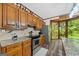 The kitchen features stainless steel appliances, wood cabinetry, and views to outdoor green space at 1627 Leguin Mill Rd, Locust Grove, GA 30248