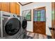 Laundry room showcasing side-by-side LG washer and dryer set, a door and a window at 1627 Leguin Mill Rd, Locust Grove, GA 30248