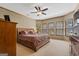 Spacious primary bedroom featuring a large bed, ceiling fan, and natural light from multiple windows at 1627 Leguin Mill Rd, Locust Grove, GA 30248
