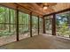 Screened porch with ceiling fan and views of the serene wooded backyard at 1627 Leguin Mill Rd, Locust Grove, GA 30248