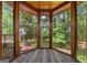 Sunroom with walls of windows overlooking wooded backyard with views of greenery at 1627 Leguin Mill Rd, Locust Grove, GA 30248