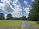 Expansive green lawn under a sunny sky with scattered trees at 1627 Leguin Mill Rd, Locust Grove, GA 30248