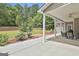 Spacious covered back patio with ceiling fan, outdoor furniture, and a serene view of the well-maintained backyard at 465 Crabapple Rd, Fayetteville, GA 30215