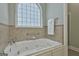 Bathroom featuring an arched grid window above a soaking tub with tile surround at 465 Crabapple Rd, Fayetteville, GA 30215