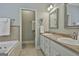 Bright bathroom with a double vanity, soaking tub, tiled accents, and linen storage at 465 Crabapple Rd, Fayetteville, GA 30215