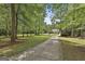 Long driveway through a tree-lined property leads to a charming home on a sprawling green lawn at 465 Crabapple Rd, Fayetteville, GA 30215