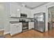 Bright kitchen features stainless steel appliances, white cabinets, and granite countertops at 465 Crabapple Rd, Fayetteville, GA 30215
