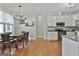 Open eat-in kitchen features stainless steel appliances, wood floors, and a chandelier-lit dining area at 465 Crabapple Rd, Fayetteville, GA 30215