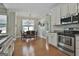 Bright eat-in kitchen features stainless steel appliances, hardwood floors, and a chandelier-lit dining area at 465 Crabapple Rd, Fayetteville, GA 30215