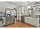 This modern kitchen features stainless steel appliances, granite countertops, and white cabinetry at 465 Crabapple Rd, Fayetteville, GA 30215