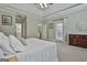 Bright main bedroom with decorative headboard, plush white bedding, and views of ensuite bath at 465 Crabapple Rd, Fayetteville, GA 30215