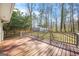 Red stained wood deck with railing overlooking a wooded back yard at 2511 Due West Nw Cir, Kennesaw, GA 30152
