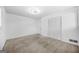 Bedroom features neutral carpeting, closet, and a modern light fixture at 2511 Due West Nw Cir, Kennesaw, GA 30152
