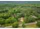 Expansive aerial view of a home nestled within a lush, green forest landscape with a long driveway at 428 Cornish Mountain Rd, Oxford, GA 30054