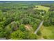 Aerial view showcases a charming property with a red roof, surrounded by lush greenery and serene landscapes at 428 Cornish Mountain Rd, Oxford, GA 30054