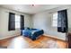 This bedroom features hardwood floors, two windows, and a calming blue comforter at 428 Cornish Mountain Rd, Oxford, GA 30054