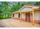 Inviting front porch featuring wood decking, brick accents, and a charming entryway with patriotic décor at 428 Cornish Mountain Rd, Oxford, GA 30054