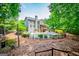 A large backyard with a pool, balcony, patio, and lots of mature trees at 125 High Bluff Trl, Carrollton, GA 30116