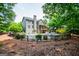 The back of the home has a pristine pool, a small balcony, and well-manicured greenery at 125 High Bluff Trl, Carrollton, GA 30116