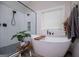 Bathroom showcasing a frameless glass shower, soaking tub, and wood-look tile flooring at 125 High Bluff Trl, Carrollton, GA 30116