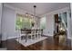 Dining room features a modern chandelier and view to the living room with fireplace at 125 High Bluff Trl, Carrollton, GA 30116