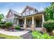 Inviting front exterior featuring a covered porch with stone columns and a seating area, enhancing the home's curb appeal and charm at 125 High Bluff Trl, Carrollton, GA 30116
