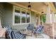Inviting front porch with stylish seating, decorative lighting, and stone accents, creating a welcoming outdoor living space at 125 High Bluff Trl, Carrollton, GA 30116