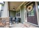 Charming front porch with comfortable striped seating, decorative wreath, and stone columns, perfect for enjoying outdoor relaxation at 125 High Bluff Trl, Carrollton, GA 30116
