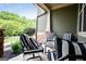 Cozy front porch with stylish striped seating, stone columns, and lush greenery, perfect for relaxing and enjoying the outdoors at 125 High Bluff Trl, Carrollton, GA 30116
