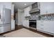 Contemporary white kitchen with stainless steel appliances and mosaic tile backsplash at 125 High Bluff Trl, Carrollton, GA 30116