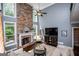 Cozy living room with high ceilings, stone fireplace and hearth, and a wall of windows with backyard views at 125 High Bluff Trl, Carrollton, GA 30116