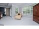 Sitting area in the primary bedroom with a chaise lounge, armoire, and windows with view of nature at 125 High Bluff Trl, Carrollton, GA 30116