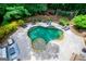 Aerial view of a beautiful backyard oasis with a uniquely shaped pool and lush landscaping at 125 High Bluff Trl, Carrollton, GA 30116