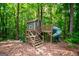 A unique treehouse with stairs and a slide are surrounded by mature trees at 125 High Bluff Trl, Carrollton, GA 30116