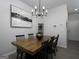 Contemporary dining room with a wooden table, black chairs, modern light fixture, and abstract art at 2108 Remy Ct, Kennesaw, GA 30144