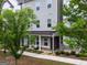 A gray townhome's entrance features a cozy, covered front porch and manicured landscaping at 2108 Remy Ct, Kennesaw, GA 30144