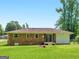 Backyard view showcasing the home's brick exterior, a well-maintained lawn, and mature trees at 840 Jett Rd, Jonesboro, GA 30236
