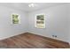 Bright bedroom with hardwood flooring and two windows offering scenic views of lush green foliage at 840 Jett Rd, Jonesboro, GA 30236
