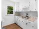 Modern kitchen with white cabinets, stone countertops, stainless steel sink, and mosaic backsplash at 840 Jett Rd, Jonesboro, GA 30236