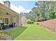 Private backyard with covered patio, ceiling fan, grassy lawn, and surrounding trees, creating a peaceful retreat at 1801 Ridgefield Dr, Peachtree City, GA 30269