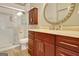 Bathroom with wood vanity, marble countertop, walk in shower, and round mirror at 1801 Ridgefield Dr, Peachtree City, GA 30269