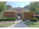 Brick community clubhouse with American flag bunting, manicured landscaping, and inviting entrance at 1801 Ridgefield Dr, Peachtree City, GA 30269