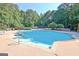 Community pool surrounded by lounge chairs, tables, and lush greenery, perfect for relaxation and recreation at 1801 Ridgefield Dr, Peachtree City, GA 30269
