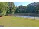 Community tennis court with a net, fence, and surrounding green space for outdoor activities at 1801 Ridgefield Dr, Peachtree City, GA 30269
