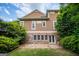 Beautiful back exterior with stone foundation, cedar shingles, and a stone patio at 115 Champion Dr, Carrollton, GA 30116