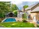 The backyard features a in-ground pool with a stone patio and a lush, green lawn at 115 Champion Dr, Carrollton, GA 30116