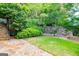 Manicured backyard featuring stone retaining walls and lush greenery at 115 Champion Dr, Carrollton, GA 30116