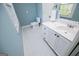 Powder blue bathroom featuring white vanity, toilet and tile flooring at 115 Champion Dr, Carrollton, GA 30116
