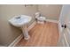 Small bathroom with decorative sink, toilet, linoleum wood flooring, and simple design at 115 Champion Dr, Carrollton, GA 30116