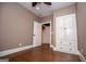 Neutral bedroom with wooden floors, ceiling fan, white trim, built-in drawers and storage, and an open closet door at 115 Champion Dr, Carrollton, GA 30116